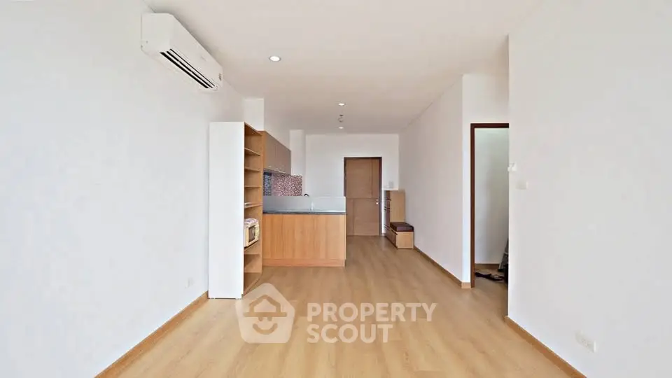 Spacious open-plan living room with modern kitchen and wooden flooring