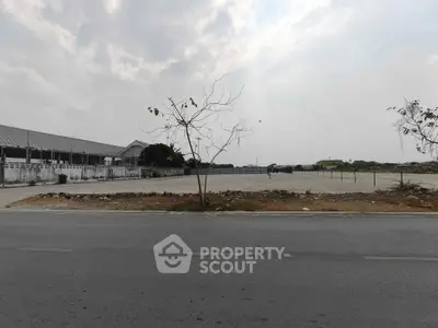 Spacious vacant land with potential for development under a cloudy sky.