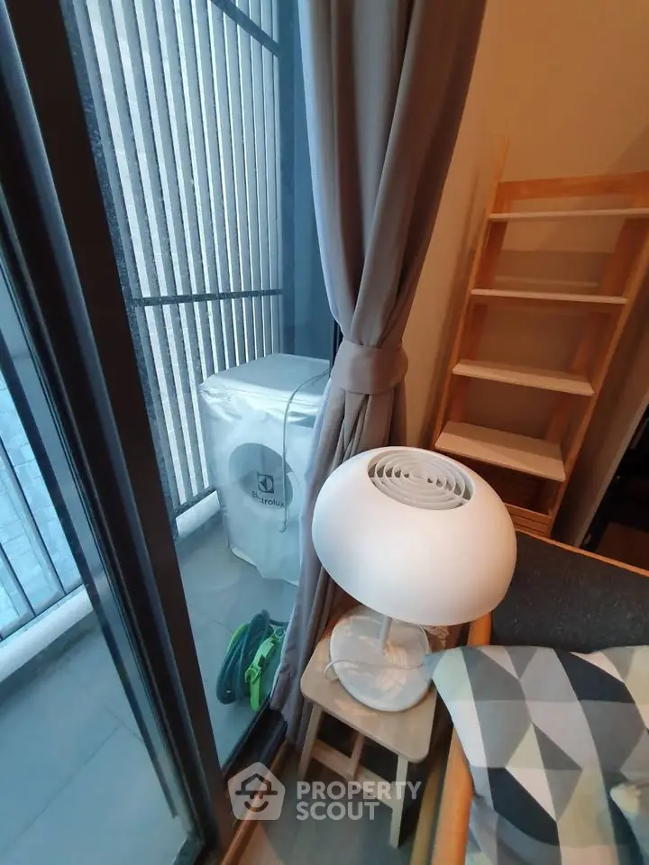 Cozy corner with modern lamp and washing machine near window in stylish apartment.