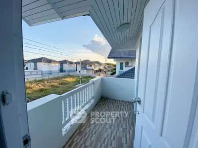 Charming balcony view in modern suburban home with tiled flooring and white railing.