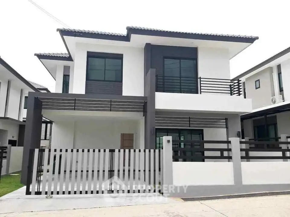 Modern two-story house with sleek design and spacious driveway in a tranquil neighborhood.