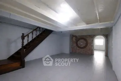 Spacious basement with unique brick wall and wooden staircase