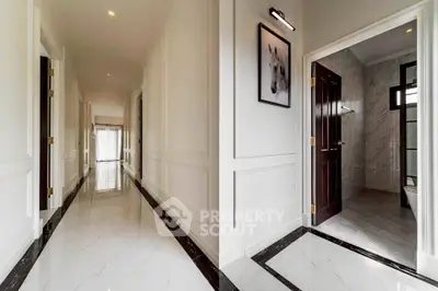 Elegant hallway with marble flooring and a glimpse into a modern bathroom