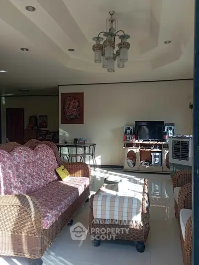 Charming living room with wicker furniture and elegant chandelier