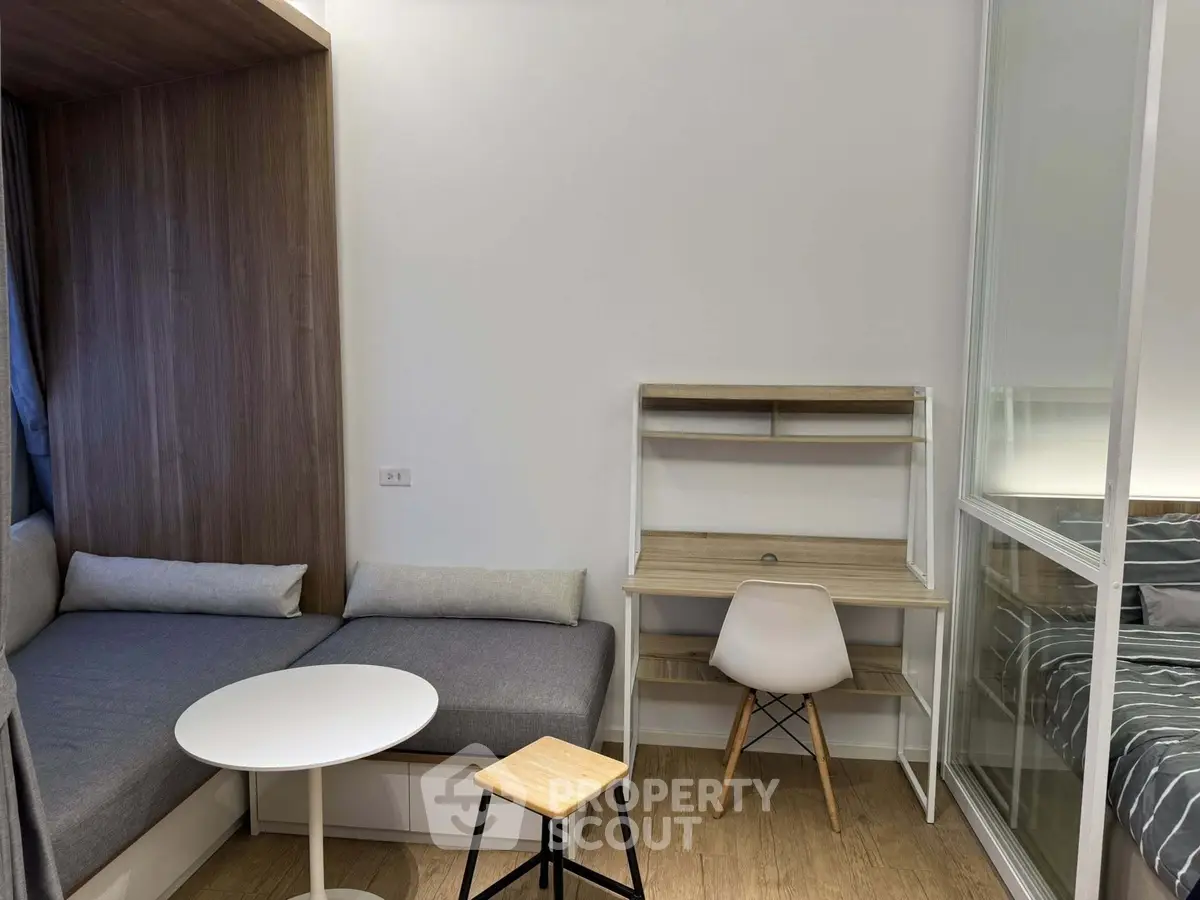 Modern compact living space with cozy seating and study area, perfect for urban living.