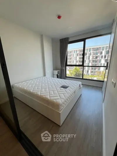 Modern bedroom with large window and minimalist design in urban apartment