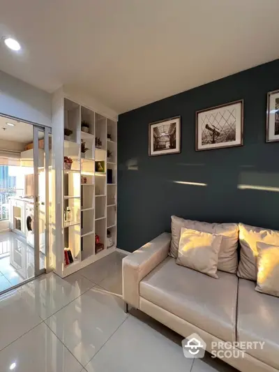 Modern living room with sleek design and natural light, featuring a cozy sofa and stylish shelving.