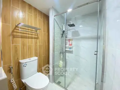 Modern bathroom with glass shower and wooden accent wall