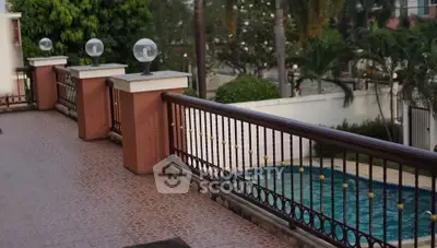Luxurious balcony overlooking a private pool and lush garden, perfect for relaxation and entertainment.