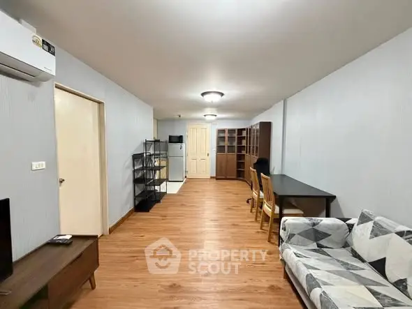 Spacious living room with modern furniture and wooden flooring in a cozy apartment.