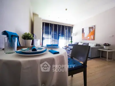 Stylish open-plan living room with dining area, featuring modern decor and abundant natural light.