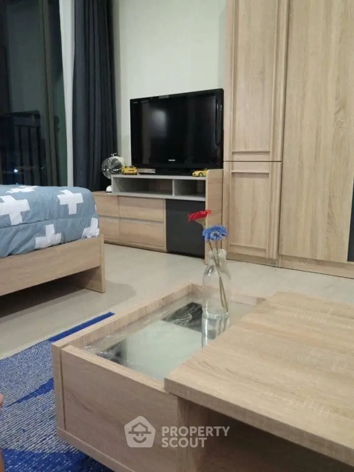 Modern bedroom with wooden furniture and flat-screen TV, perfect for cozy living.