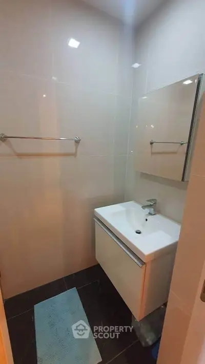 Compact modern bathroom with sleek sink and mirror, ideal for urban living.