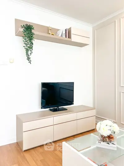 Modern living room with sleek TV stand, wall shelf, and elegant decor in a bright, minimalist setting.