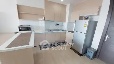 Modern kitchen with sleek cabinetry and stainless steel appliances in a stylish apartment.