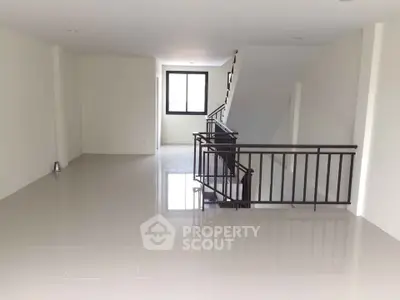 Spacious open-plan interior with sleek tiled flooring and modern staircase, ideal for customization.