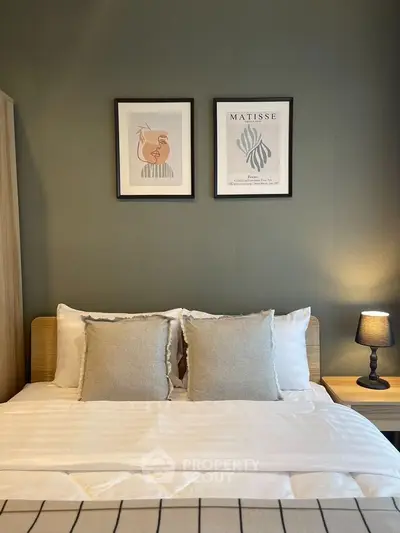 Cozy bedroom with elegant decor and framed art above bed, perfect for relaxation.
