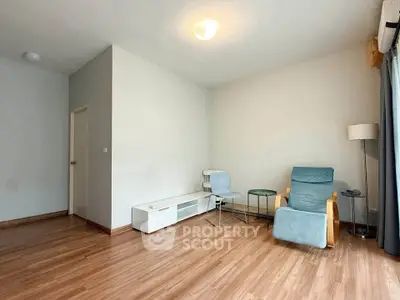 Spacious living room with modern furniture and wooden flooring, perfect for relaxation.