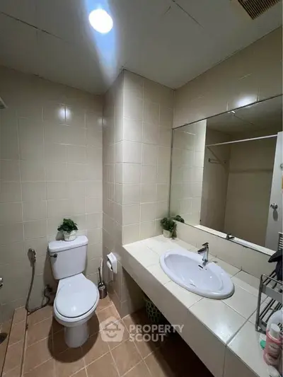 Modern bathroom with sleek fixtures and large mirror in a contemporary apartment.