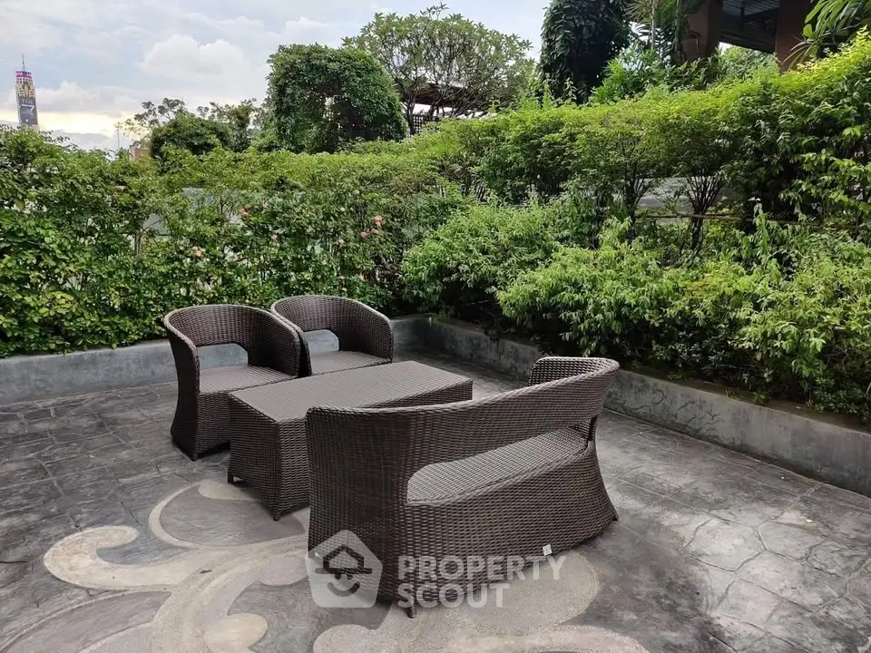 Charming outdoor garden patio with stylish wicker furniture and lush greenery, perfect for relaxation and entertaining.
