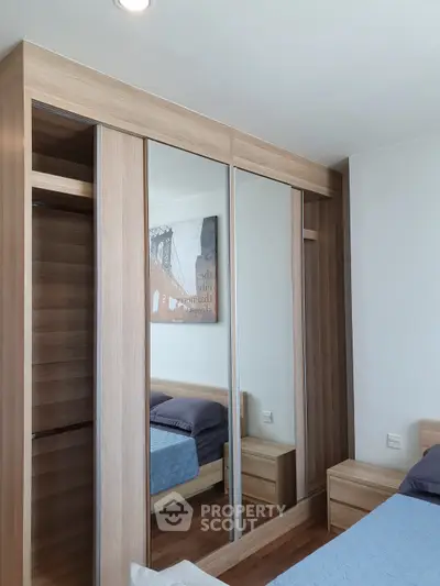 Modern bedroom with mirrored wardrobe and wooden furniture