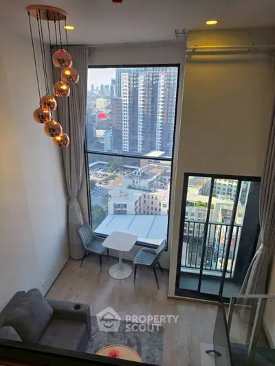 Modern living room with floor-to-ceiling windows and city view, featuring stylish lighting and cozy seating area.