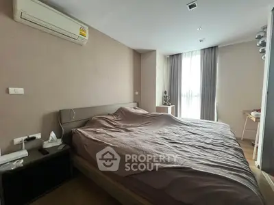 Spacious bedroom with large window and air conditioning in modern apartment.