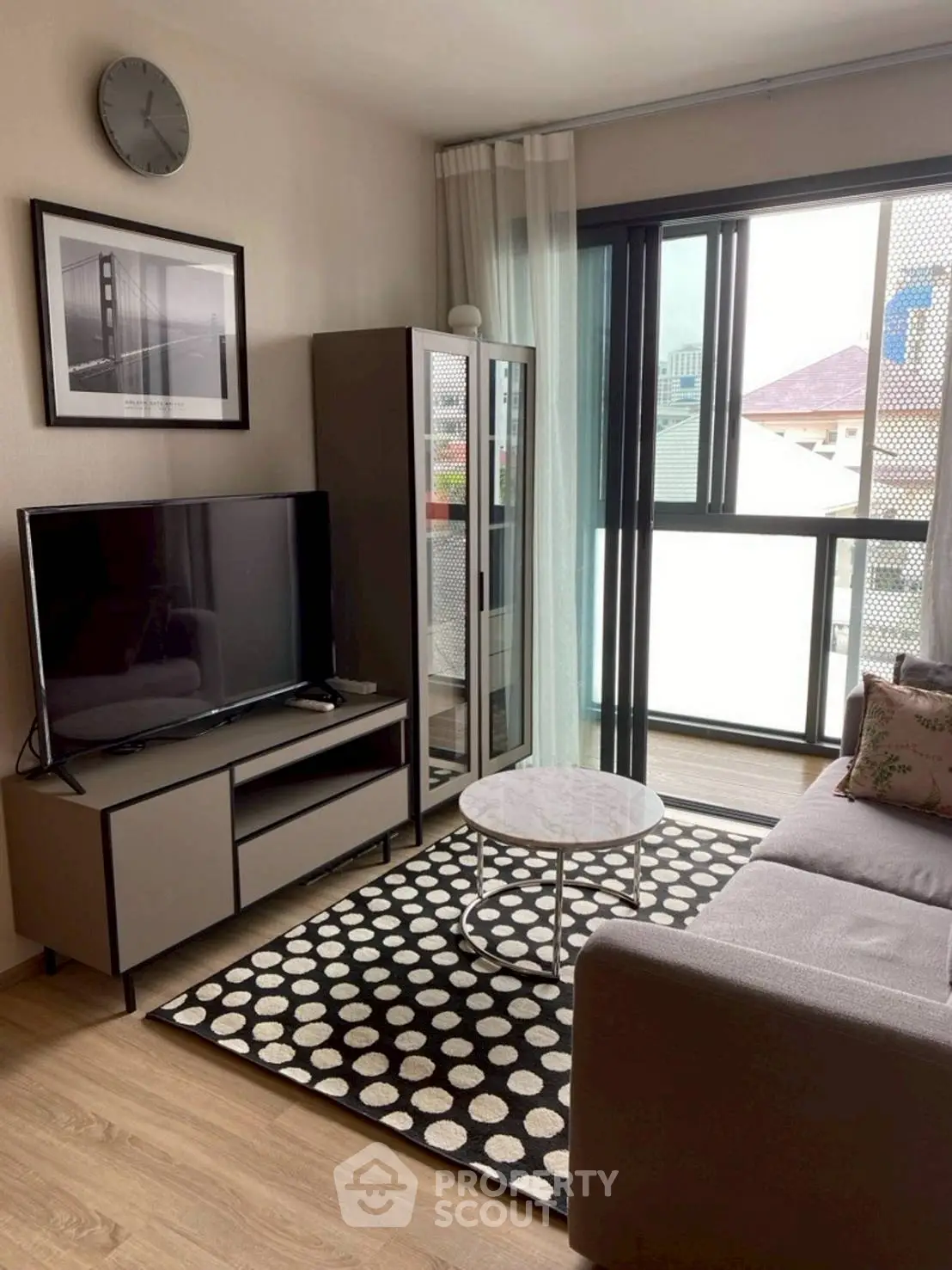 Modern living room with stylish decor, large window, and cozy seating area.