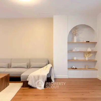 Modern living room with stylish gray sofa and elegant wooden shelves, perfect for cozy relaxation.
