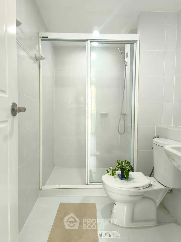 Modern bathroom with glass shower and white fixtures, perfect for a sleek home design.