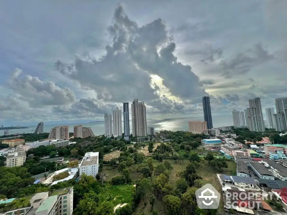 Stunning high-rise cityscape view with ocean backdrop and lush greenery