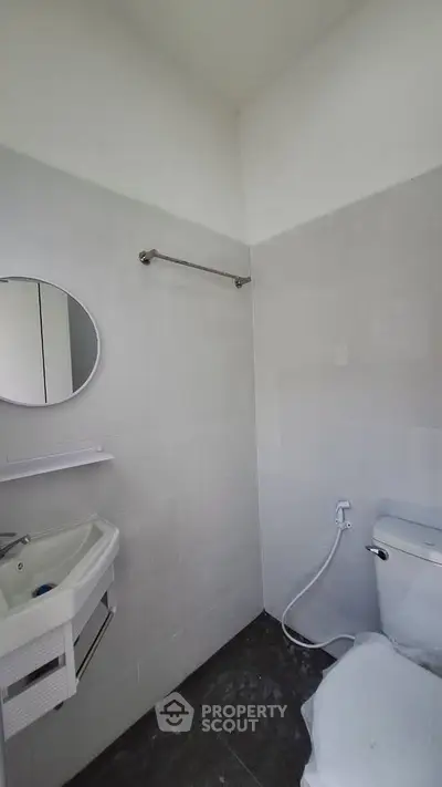 Modern minimalist bathroom with sleek fixtures and white tiles.