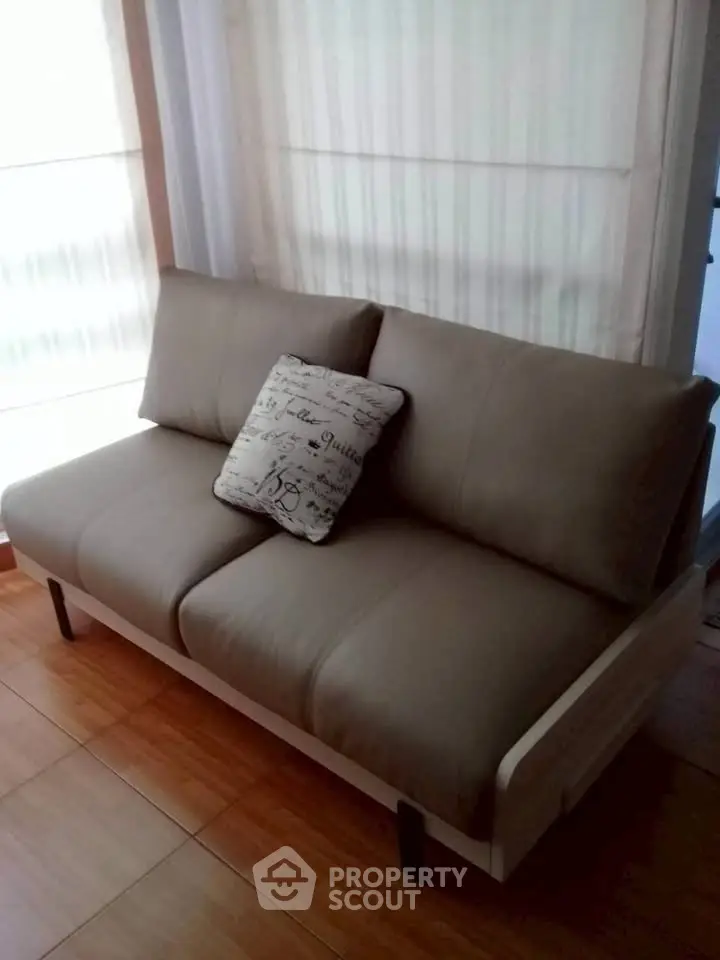 Cozy living room with stylish sofa and decorative pillow, perfect for relaxation.