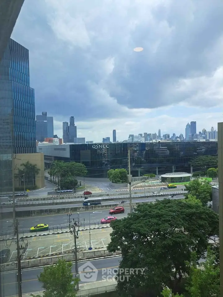 Stunning cityscape view from a high-rise building window, showcasing urban skyline and lush greenery.