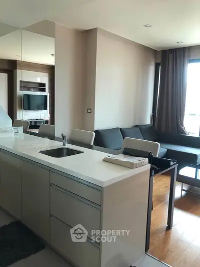 Modern open-layout kitchen and living room with sleek design and natural light.