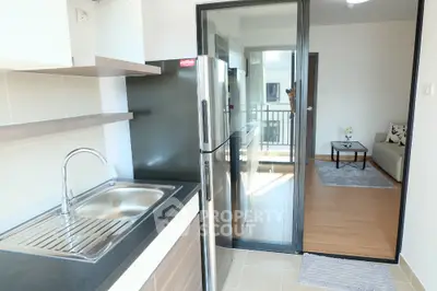 Modern kitchen with sleek design and open layout leading to cozy living room
