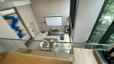 Stunning modern living room with high ceilings and large windows offering lush greenery views.