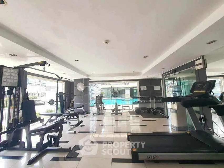 Spacious modern gym with pool view in luxury real estate property