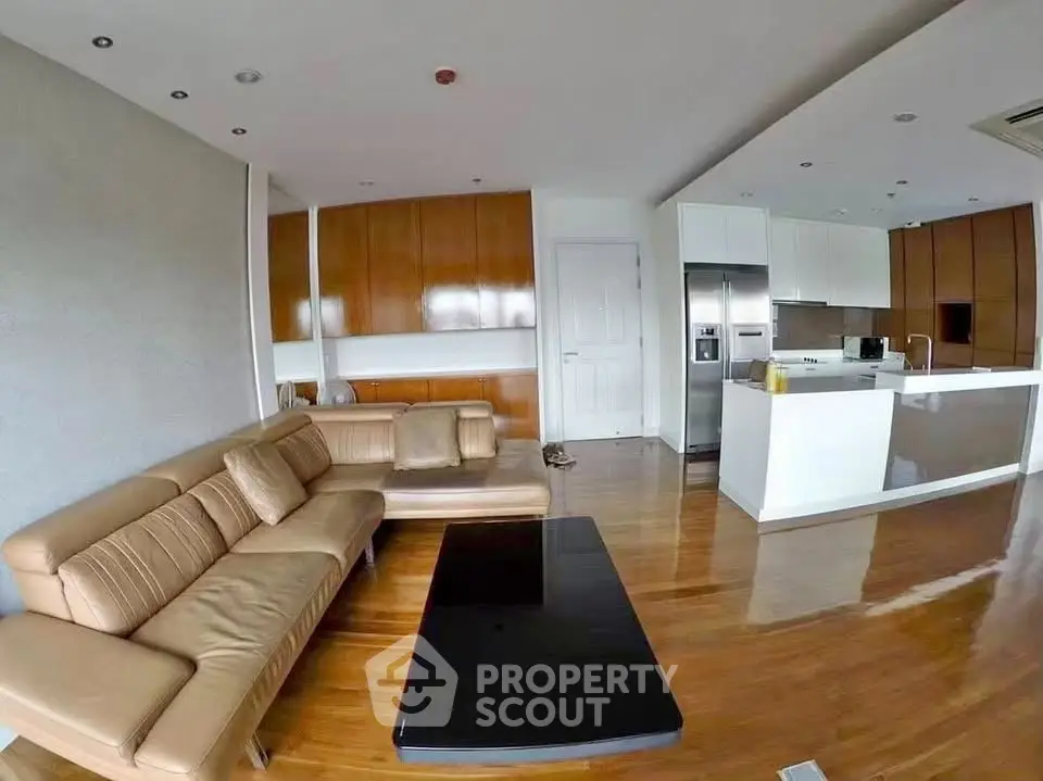 Spacious modern living room with open kitchen and sleek wooden flooring