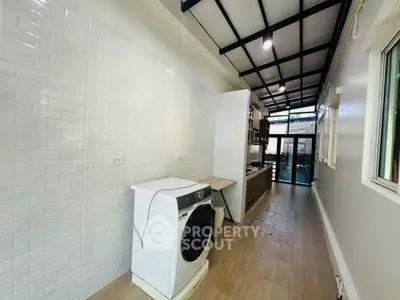 Modern kitchen with sleek design and washing machine, featuring open layout and stylish finishes.