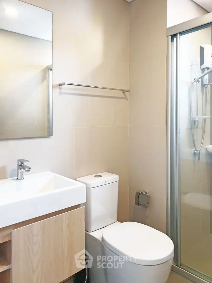 Modern bathroom with sleek fixtures and glass shower enclosure.