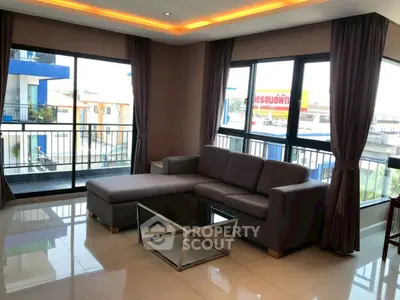 Modern living room with large windows and stylish sofa in a bright apartment.