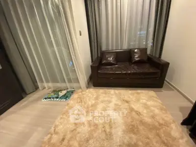 Cozy living room with leather sofa and plush rug, perfect for relaxation.