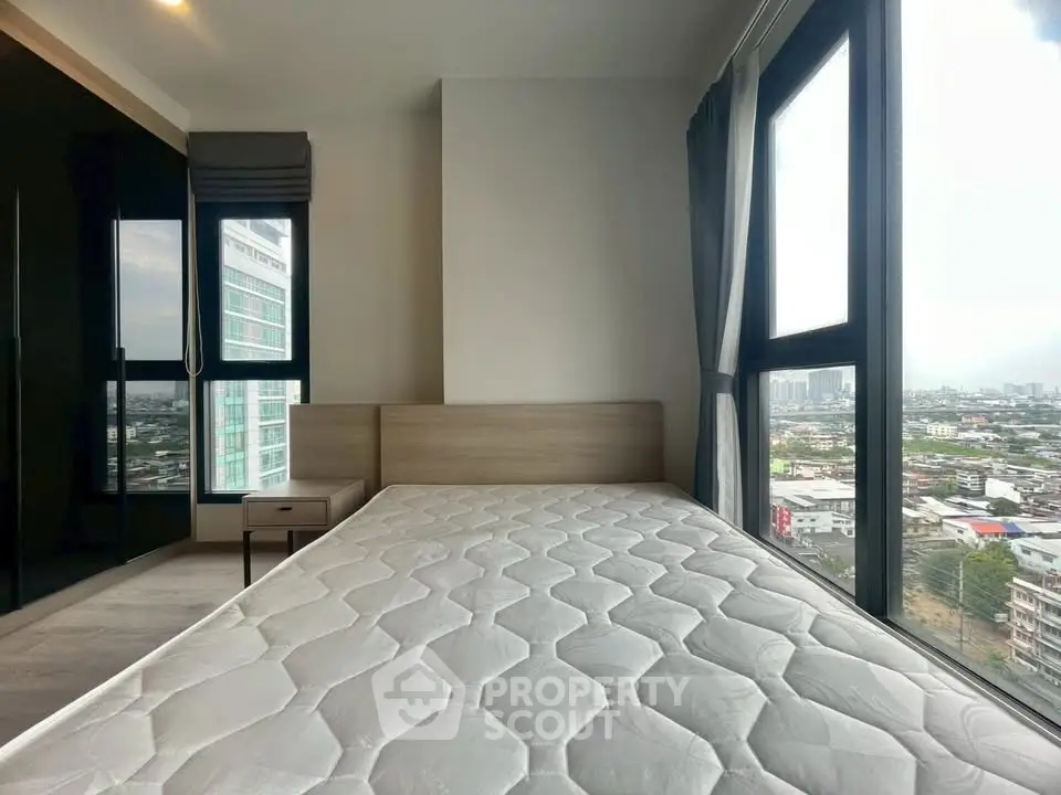 Modern bedroom with large windows offering stunning city views