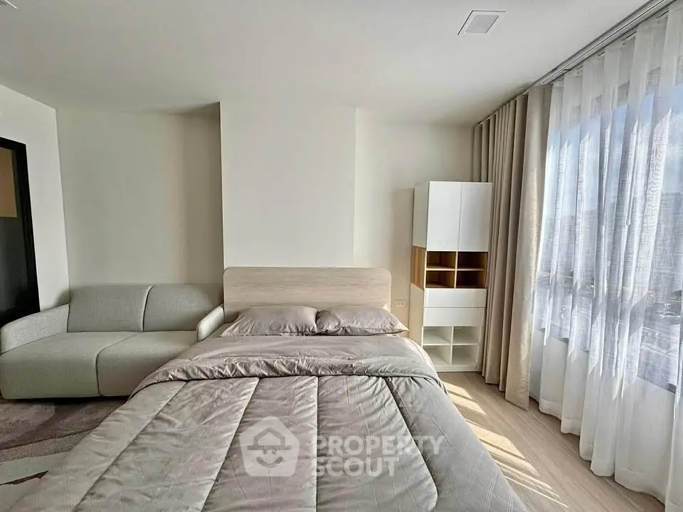 Modern bedroom with cozy bed and natural light through large window