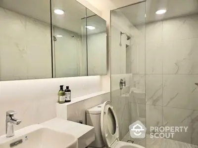 Modern bathroom with glass shower and sleek fixtures in luxury apartment