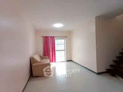 Bright living room with pink curtains and cozy sofa, perfect for relaxation.