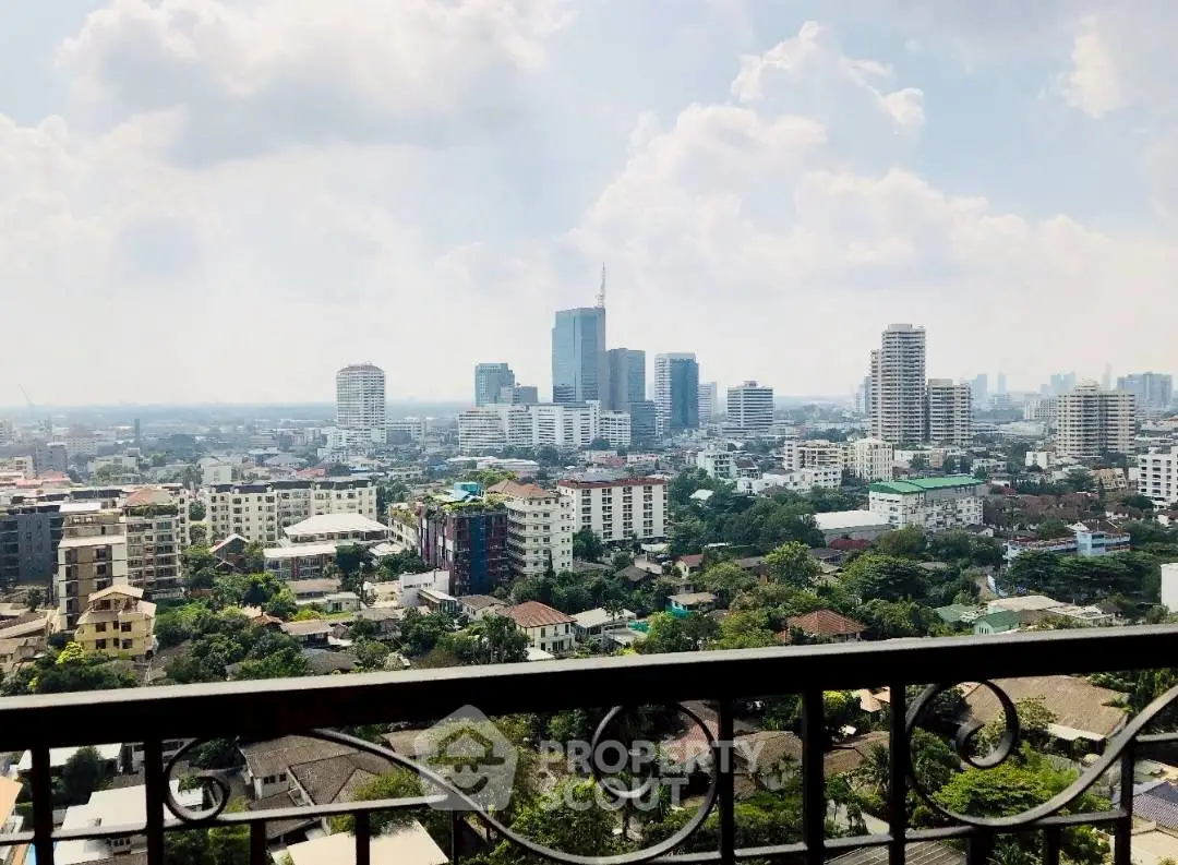Stunning cityscape view from a high-rise balcony showcasing urban skyline and lush greenery.