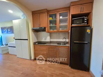 Charming kitchen with wooden cabinets and modern appliances in cozy apartment.