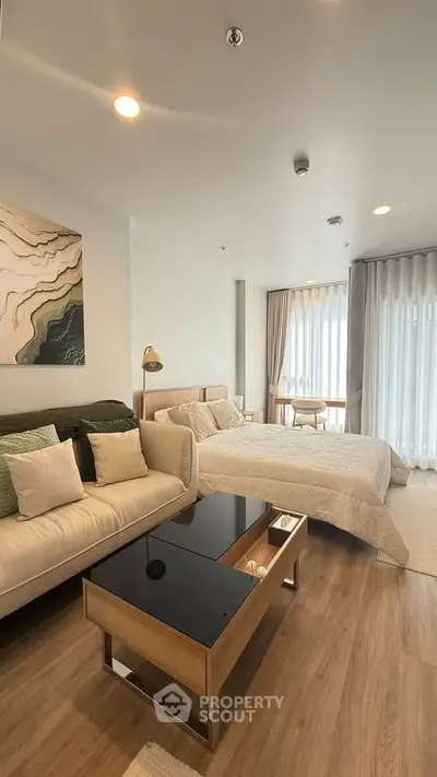 Modern bedroom with cozy seating area and natural light